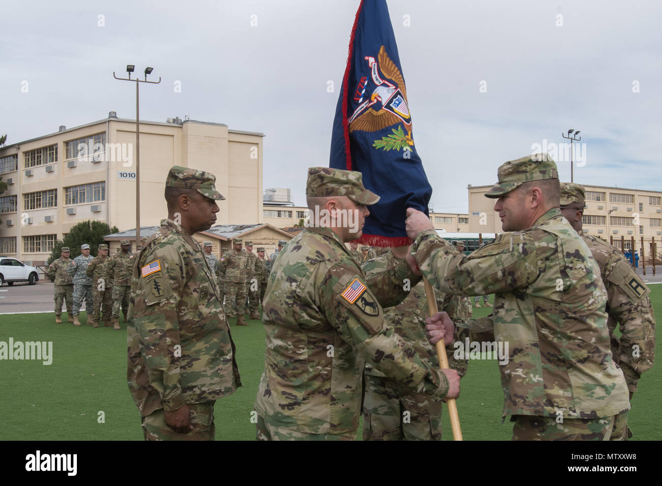 Col. Paul Garcia, the outgoing commander, presents Lt. Col. Michael Child, the incoming commander, the CRC colors representing the Transfer of Authority to the 1st Battalion, 304th Infantry Regiment, 4th Brigade of 98th Training Division (Initial Entry Training) at Fort Bliss, Texas, January 13, 2017. Stock Photo
