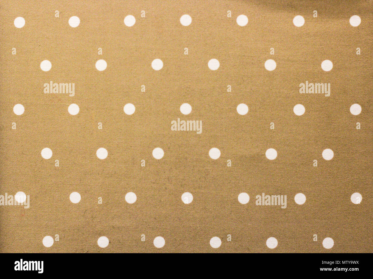 Golden fabric and a white tiny polka dots background Stock Photo