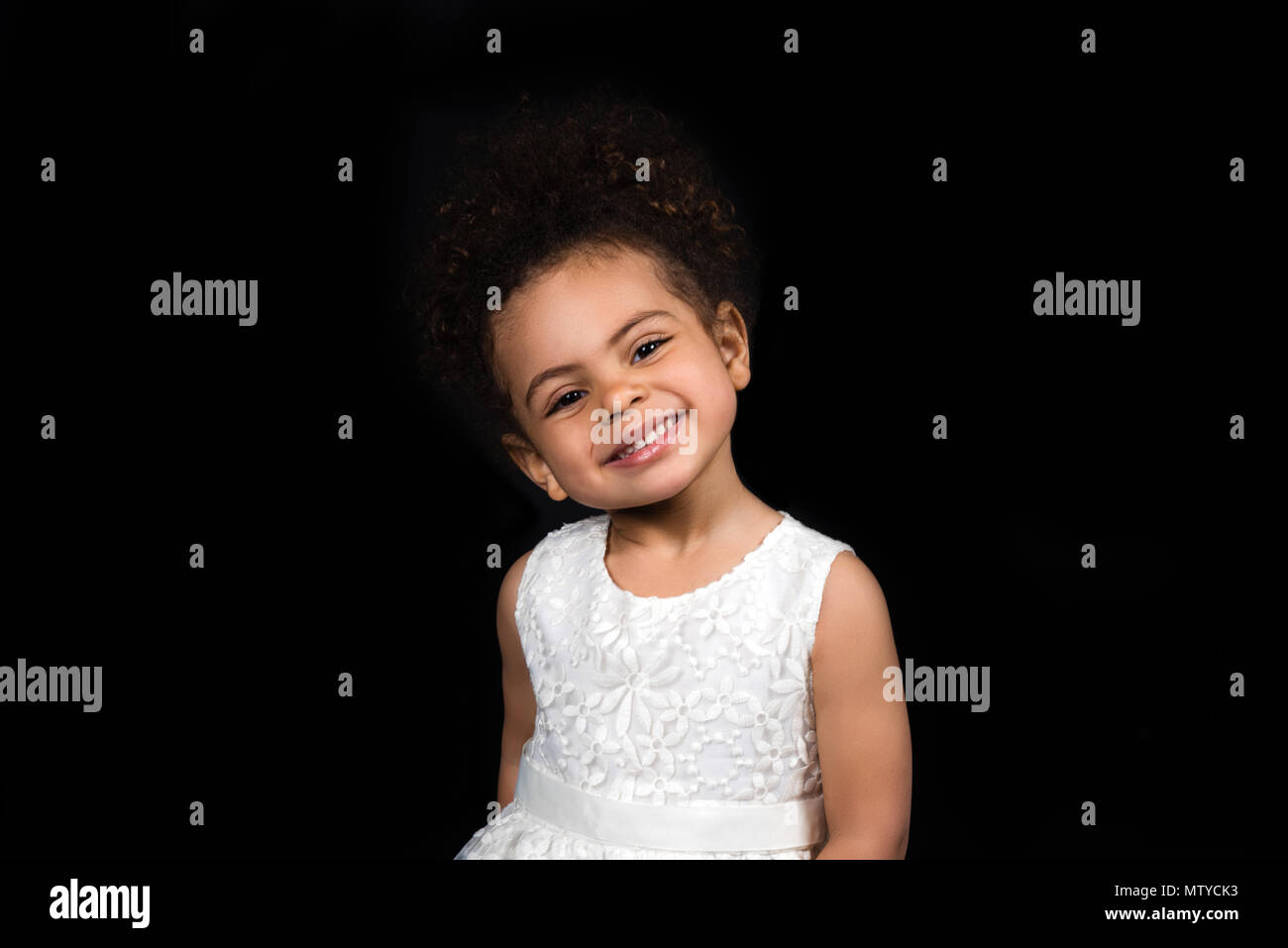 Preschooler African american child standing in a white dress and