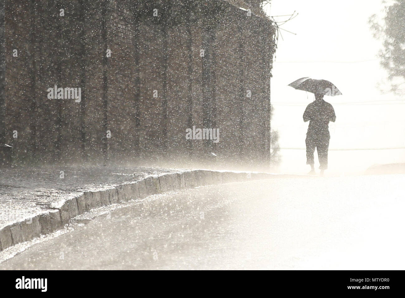 Kathmandu, Nepal. 30th May, 2018. A man silhouetted holds an umbrella