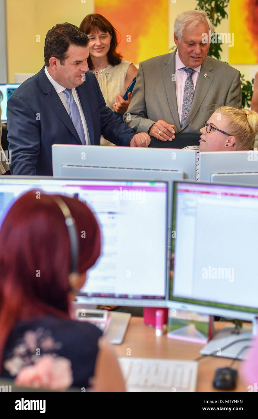31 May 2018, Germany, Cottbus: Hubertus Heil (l-r, SPD), German Minister of Labour and Social Affairs; Daniela Reuter, head of the minijob centre; and Ulrich Freese, SPD Bundestag member, learn about the work of Lisa Kutzmann, telephone agent at the Minijob-Zentrale (lit. minijob centre). Photo: Patrick Pleul/dpa-Zentralbild/ZB Stock Photo
