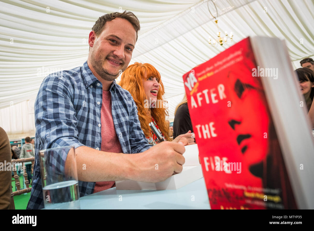 The Hay Literature Festival, Hay on Wye, Wales UK Thursday, 31 May 2018.   Writer WILL HILL, who has won the 2018 The Bookseller's YA (Young Adult)  for his novel 'After the Seige' . The prize was announced at a special cerrmony on the 8th day of the 31st annual Hay Festival of Literature and the Arts. Shown here signing copies of his winning book  in the festival bookshop after the event. Photo © Keith Morris / Alamy Live News Stock Photo