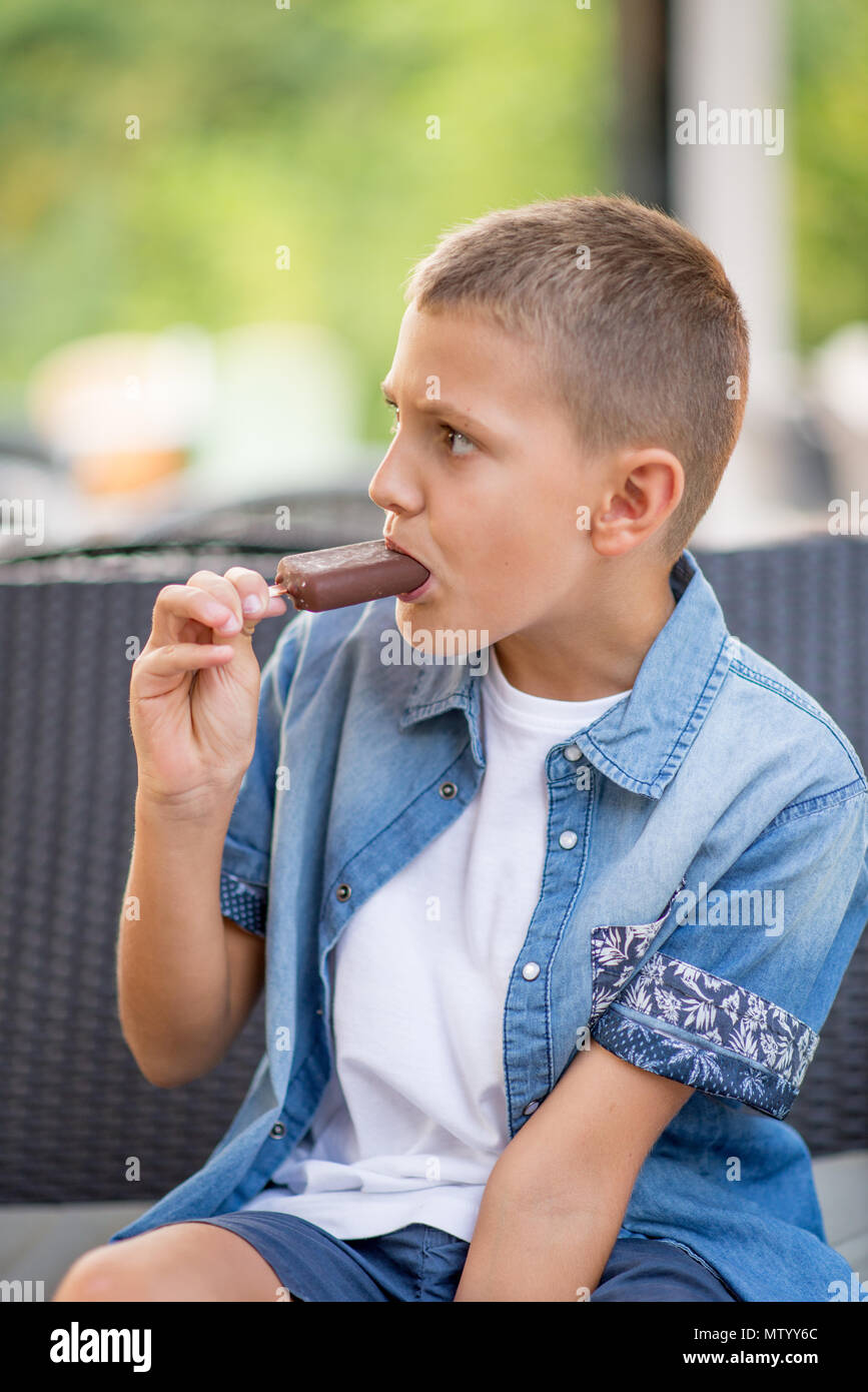 Boy siting outdoors eating an ice-cream Stock Photo