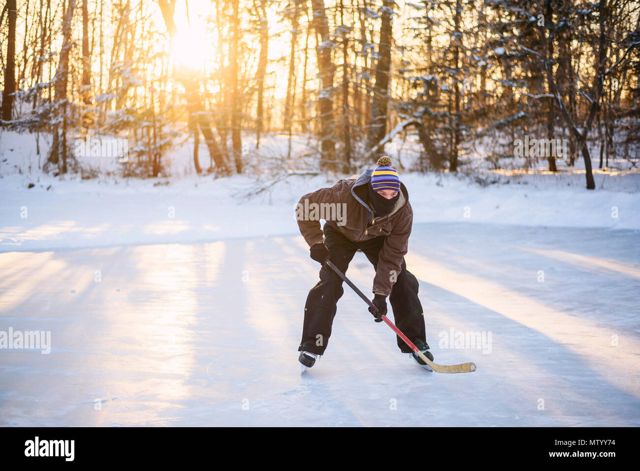 Man playing ice hockey on a frozen lake Stock Photo