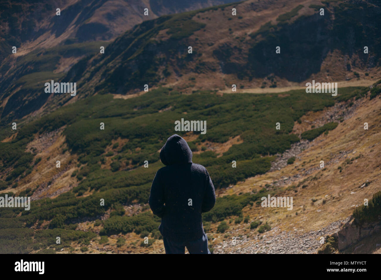 Man wearing a hoodie looking at mountain view, Ukraine Stock Photo