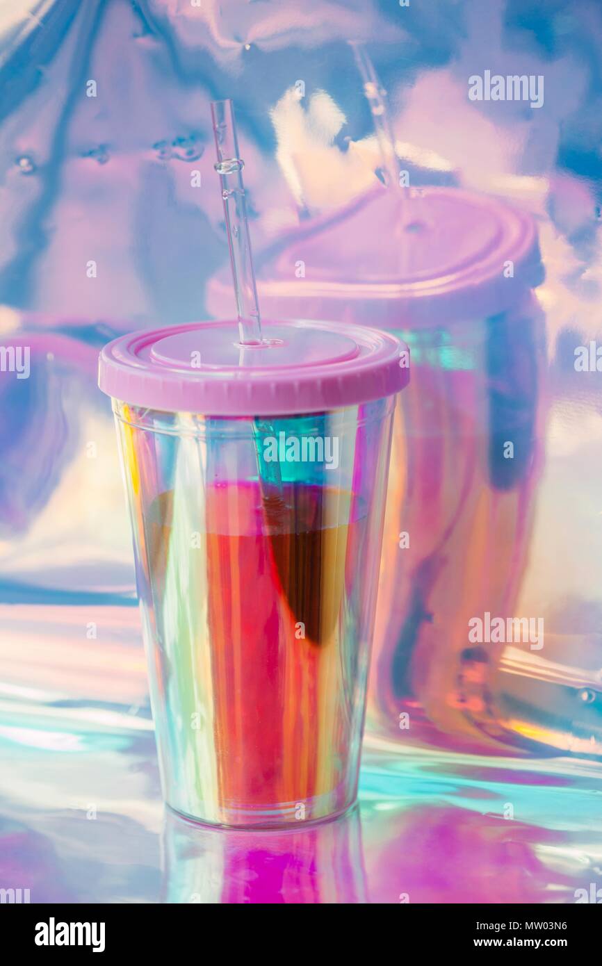 Plastic cup with a drinking straw on silver foil Stock Photo