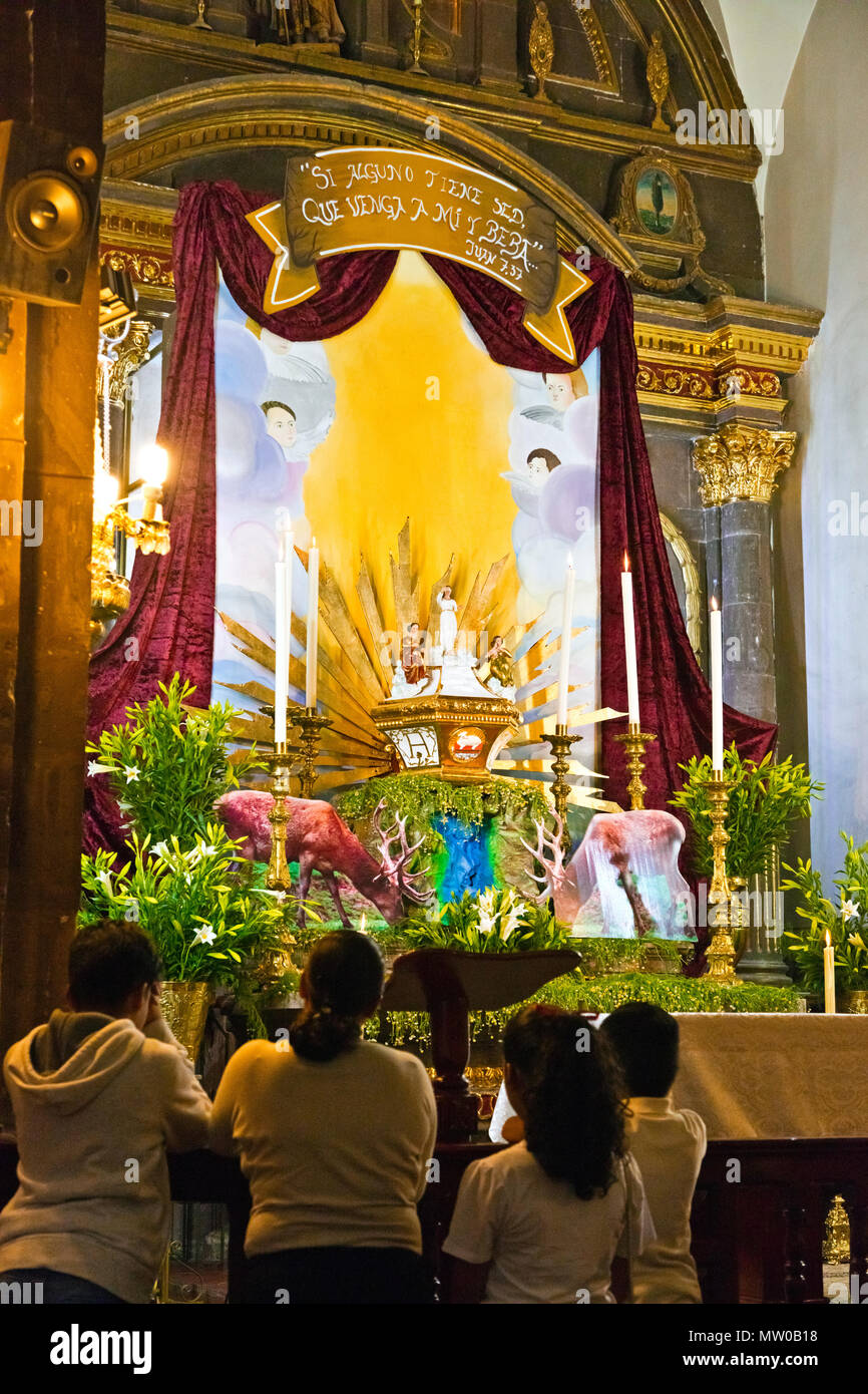 Catholics worship at an EASTER ALTAR on Good Friday at the ORATORIO CHURCH  - SAN MIGUEL DE ALLENDE, MEXICO Stock Photo