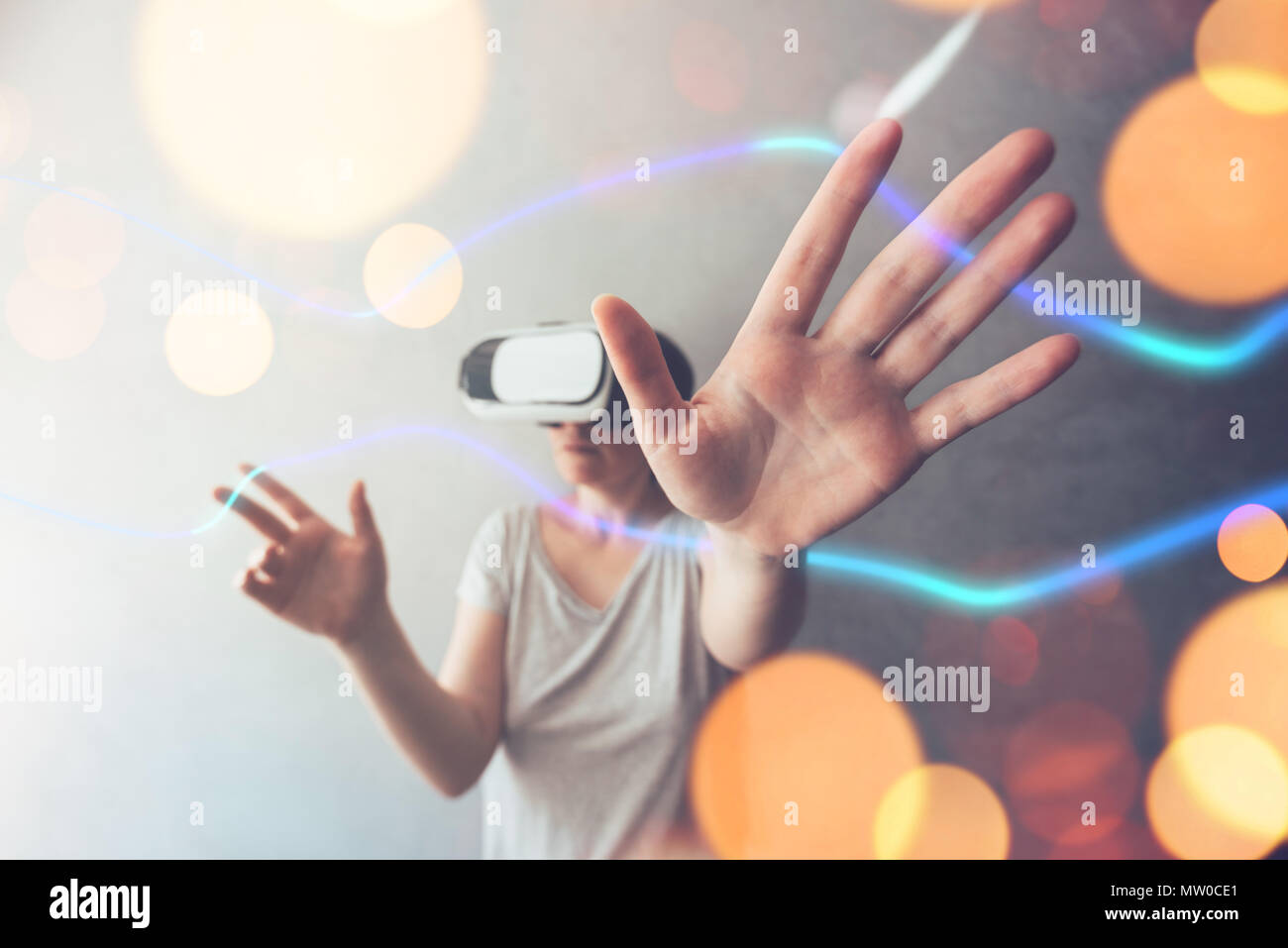 Woman using VR headset. Conceptual mixed media image of female person immersed in virtual reality. Stock Photo