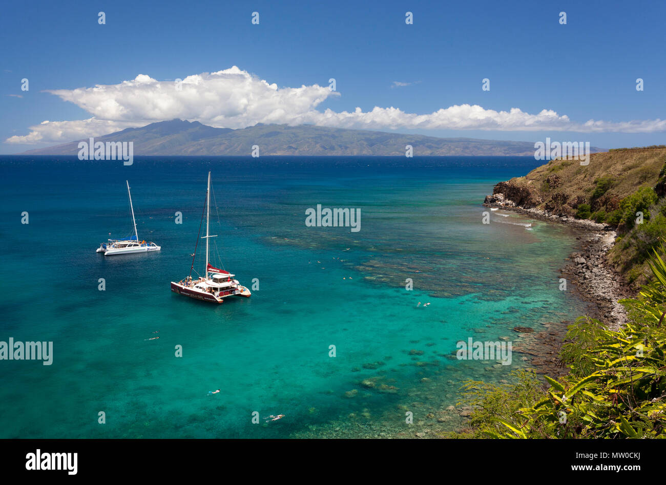 Boats anchored at Honolua Bay, Maui, Hawaii. Molokai is in the distance. Stock Photo