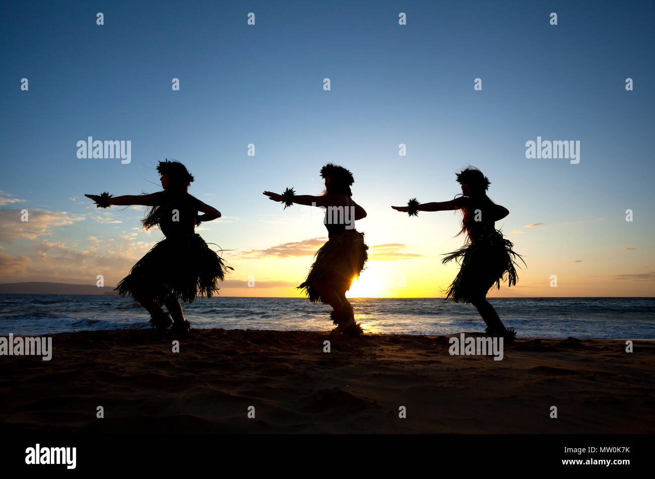 Three hula dancers at sunset at Wailea, Maui, Hawaii. Stock Photo