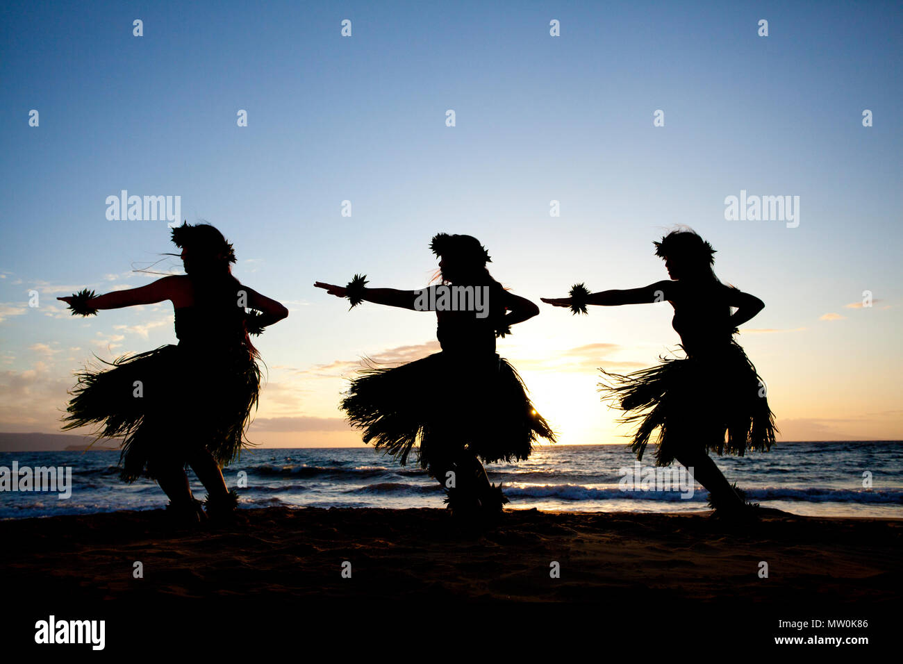 Three hula dancers at sunset at Wailea, Maui, Hawaii. Stock Photo