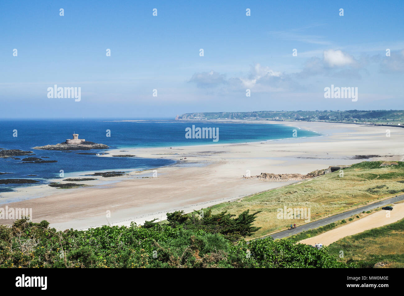 Beautiful view of St. Ouen's Bay and La Rocco Tower at low tide on a beautiful sunny day - Jersey, Channel Islands Stock Photo