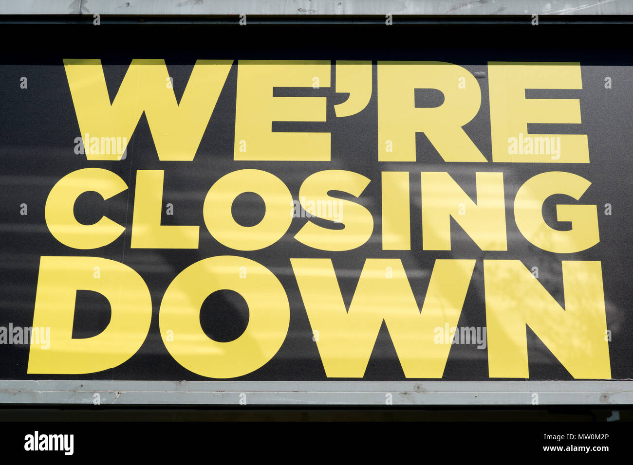 A sign reads 'We're Closing Down' on the site of a former JD Sports store located off Great Ancoats Street in Manchester. Stock Photo