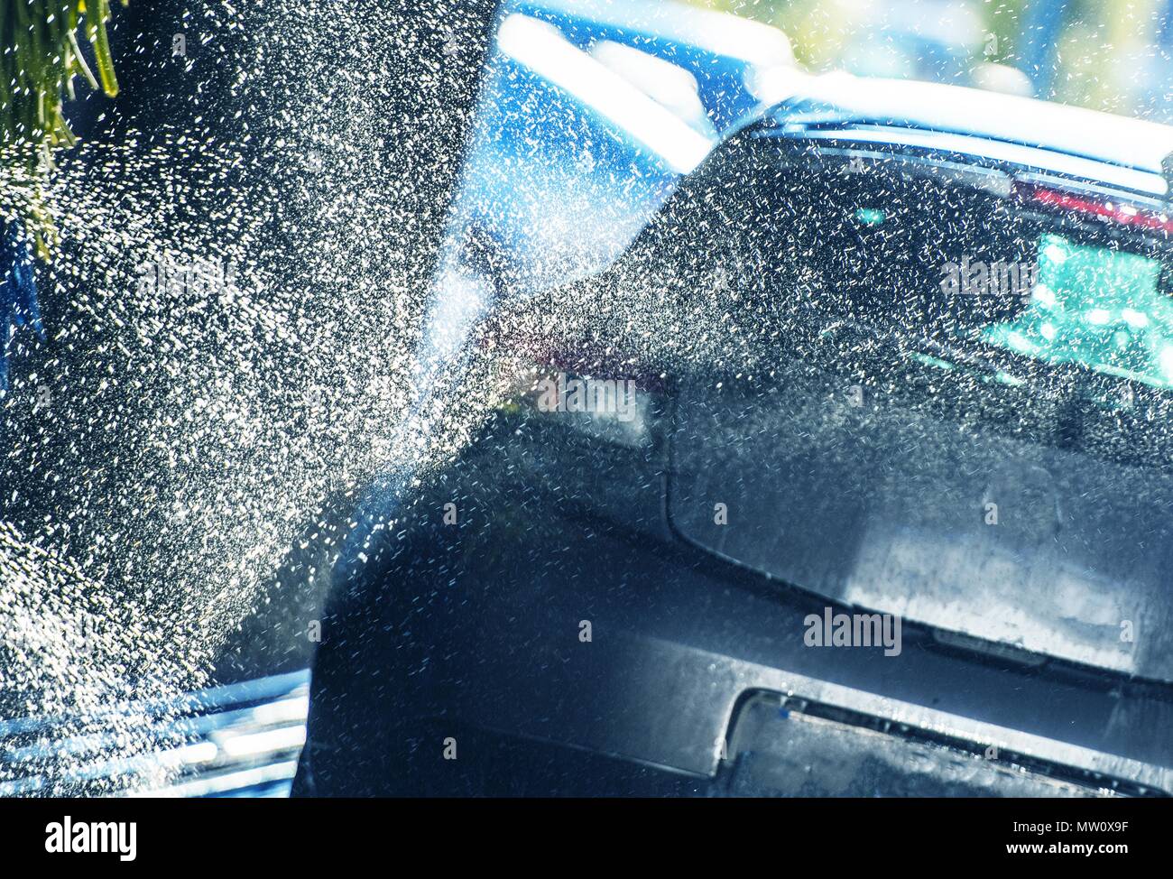 Vehicle Washing in the Car Wash. Automatic Washer Spraying the Car with Active Body Cleaning Foam Stock Photo