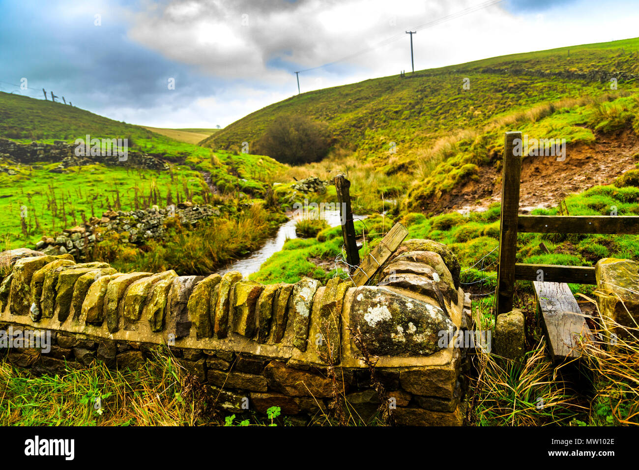 A stile on the rolling green walking hills of Derbyshire Stock Photo