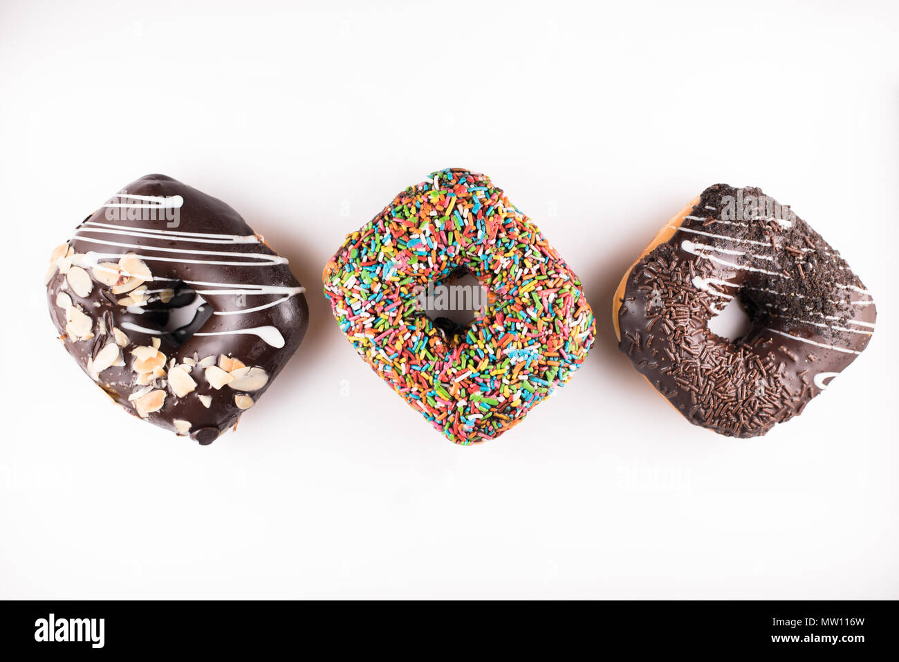 three square doughnut with different toppings isolated on white background. sweet food and unhealthy eating concept Stock Photo