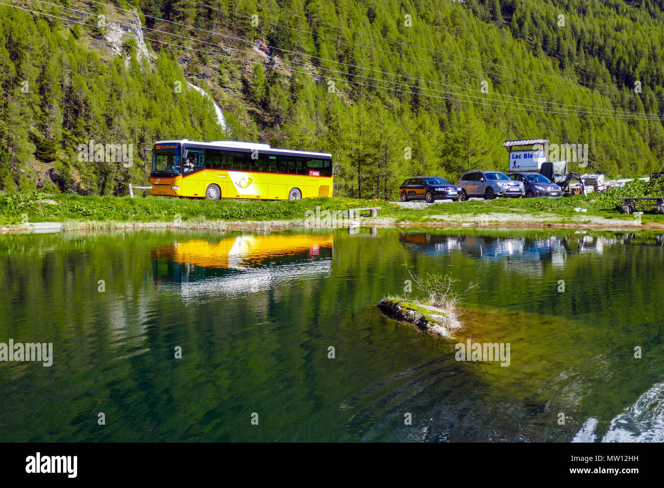 PostBus with reflections in the Saas Tal, Valais, Switzerland Stock Photo