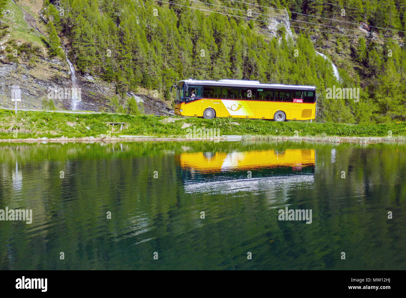 PostBus with reflections in the Saas Tal, Valais, Switzerland Stock Photo