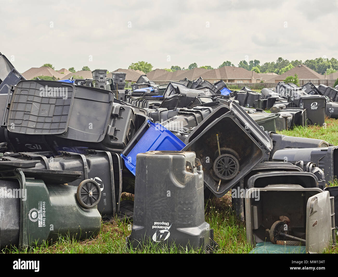 Large plastic trash cans discarded and piled or stacked in a field waiting for removal in Pike Road Alabama, USA. Stock Photo