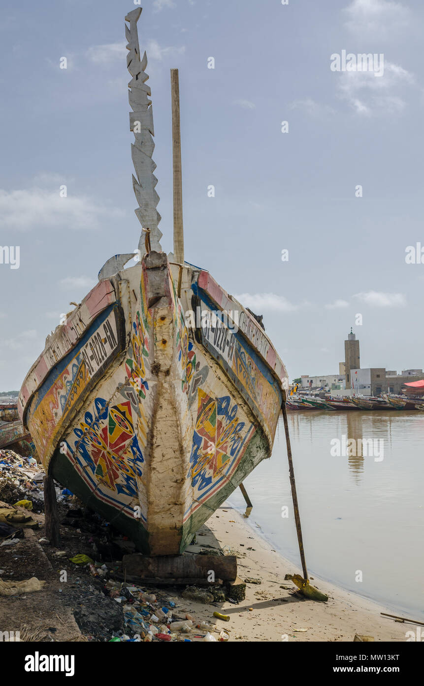 St Louis, Senegal - October 12, 2014: Colorful painted wooden fishing boats or pirogues at coast of St. Louis. Stock Photo