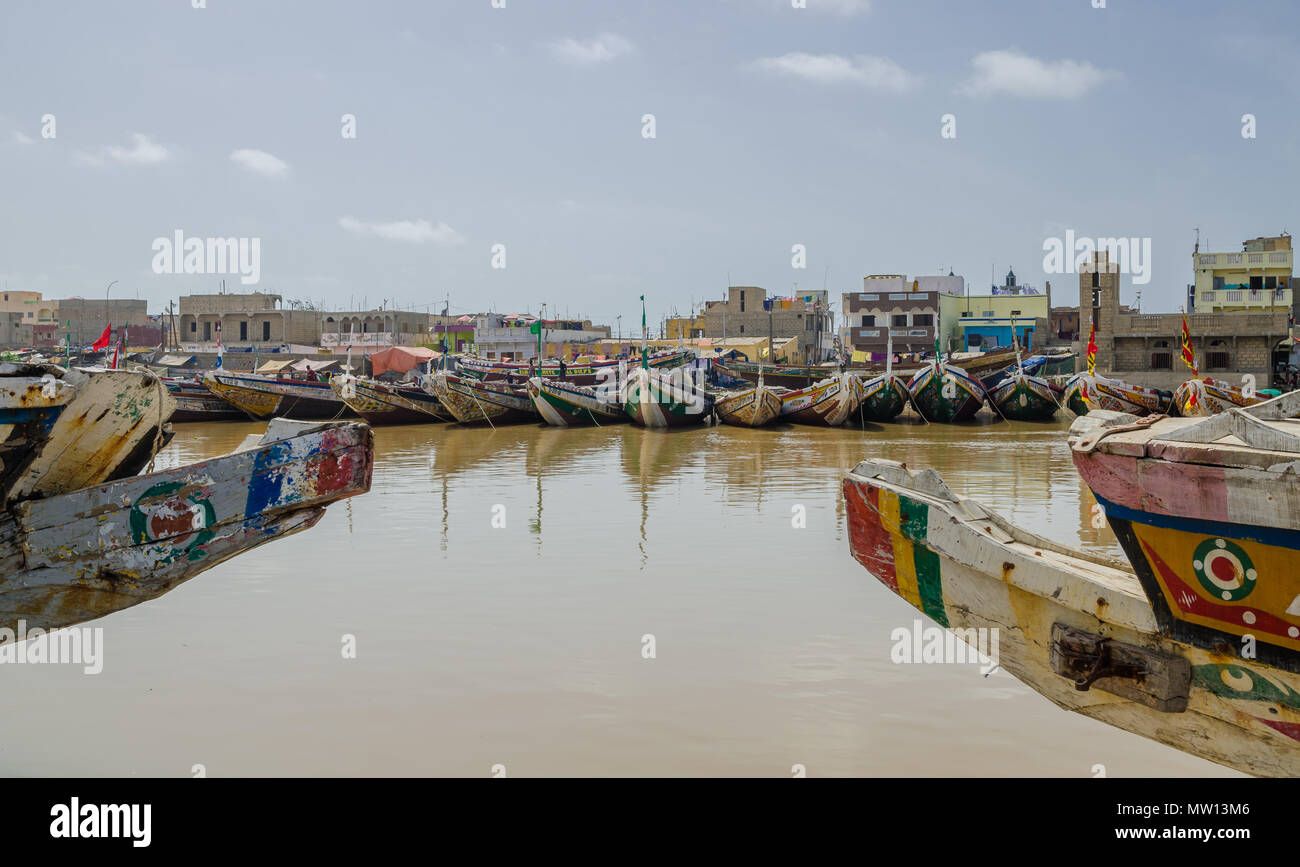 St Louis, Senegal - October 12, 2014: Colorful painted wooden fishing boats or pirogues at coast of St. Louis. Stock Photo