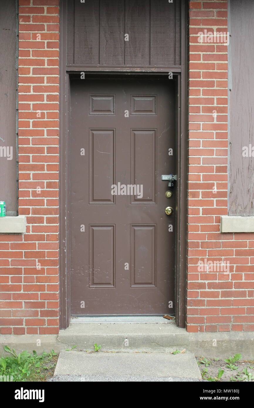 Weathered and padlocked door painted dark brown and located in a cute