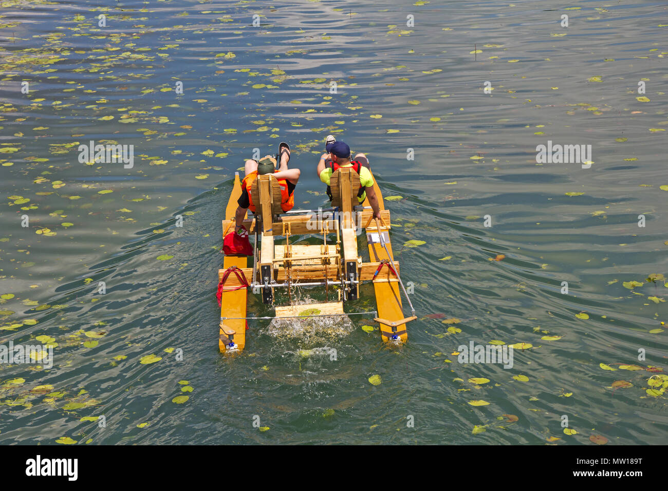 Two man ride with floating pedal bicycle boats across the lake Stock Photo