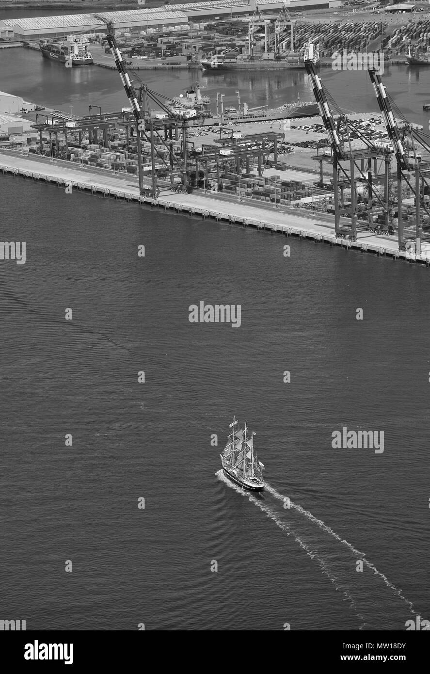 Tall ships passing tall container cranes on the banks of the River Mersey Liverpool Stock Photo