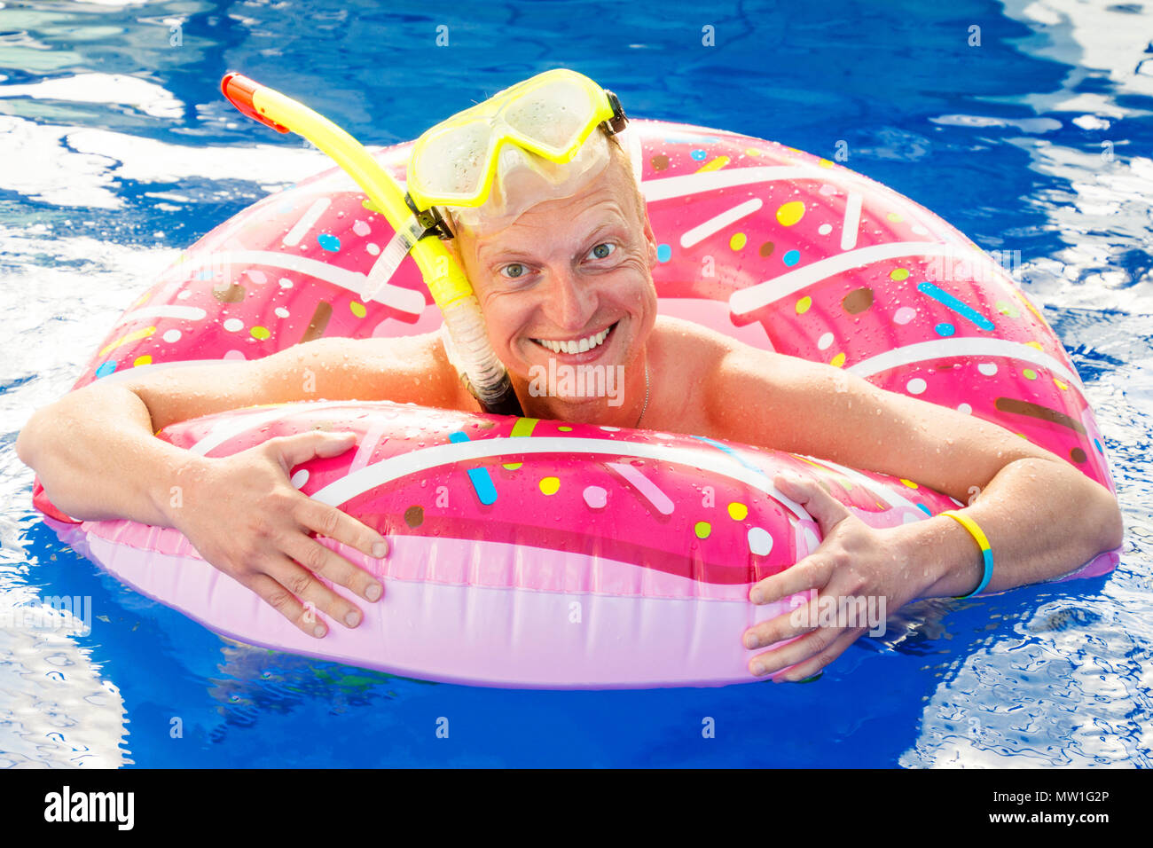Portrait of a funny young man in swim goggles and inflatable ring
