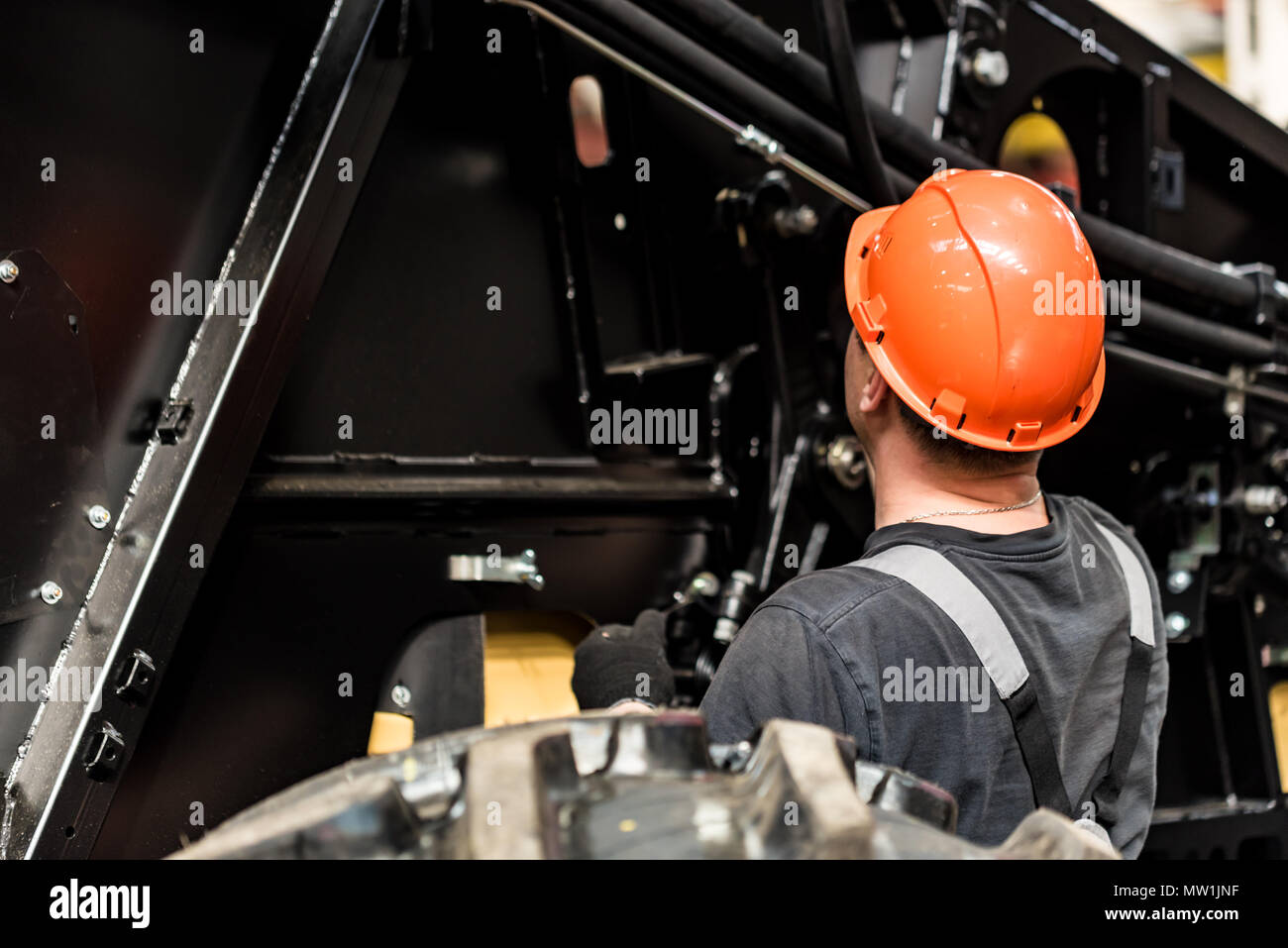 Industrial worker assembles agricultural equipment Stock Photo