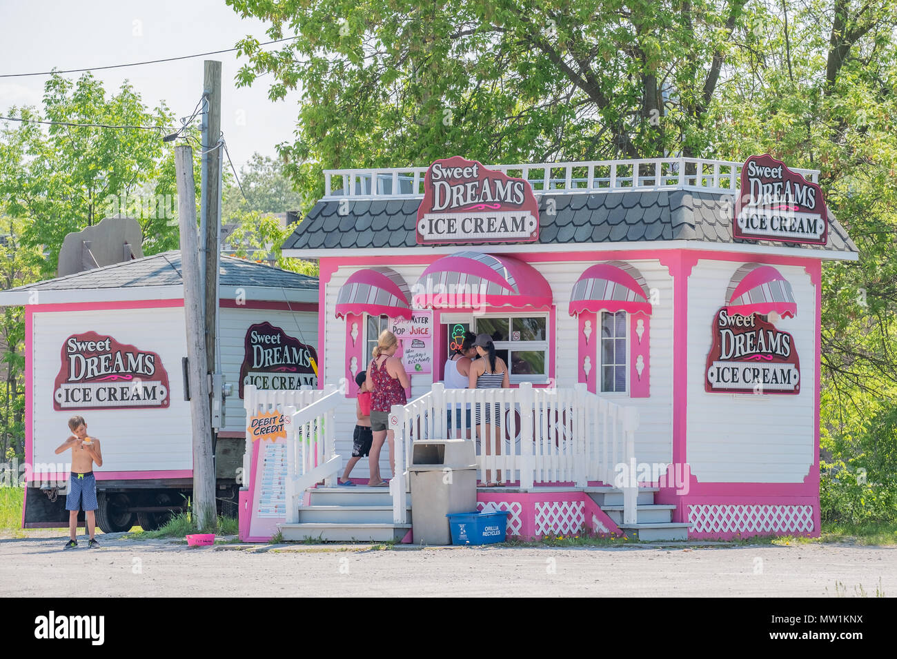 People ordering ice cream on a hot day from a shop on the Orillia Ontario Canada lakefront. Stock Photo