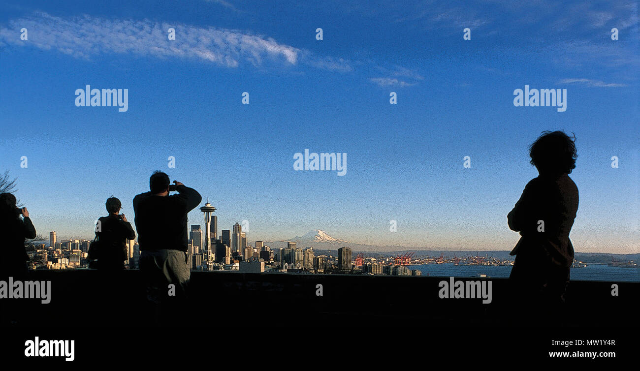 Seattle skyline with Space Needle and Mt. Rainier from Kerry Park with tourists taking photos, one observing (rendered in PS), Seattle, WA, USA Stock Photo