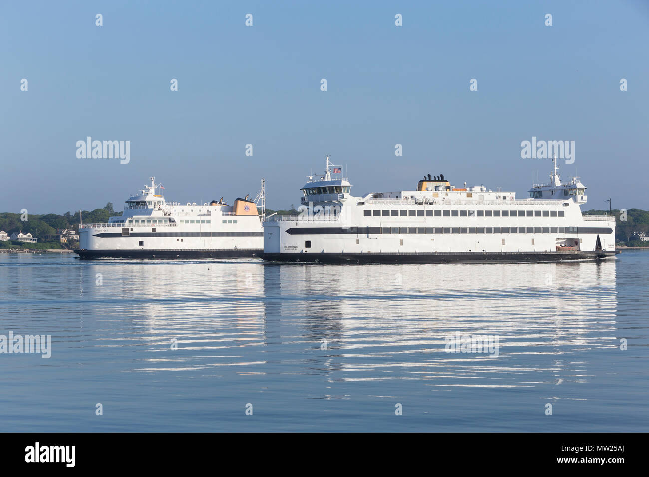 Steamship Authority ferries 'MV Island Home' and 'MV Woods Hole' pass in Vineyard Haven harbor on the run between Woods Hole and Martha's Vineyard. Stock Photo