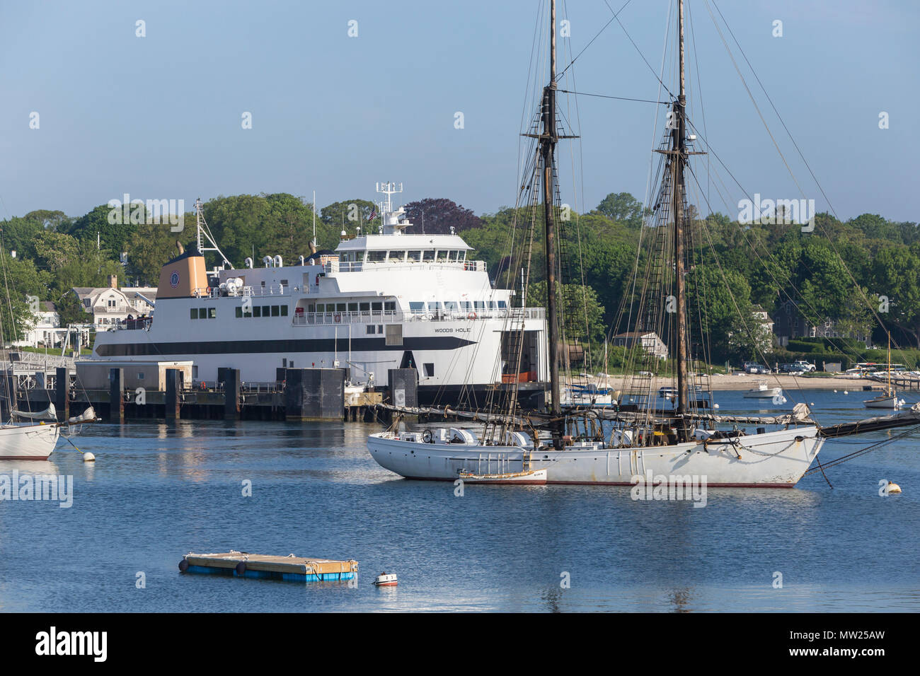 Steamship Authority ferry 'MV Woods Hole' waits to depart from Vineyard Haven on Martha's Vineyard behind two-masted schooner 'Alabama'. Stock Photo