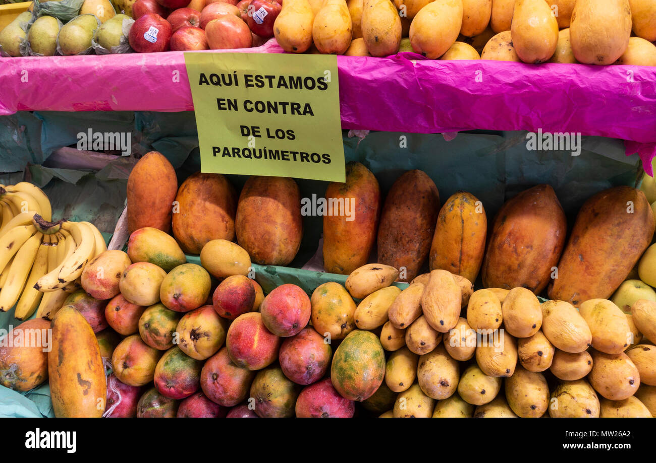 A sign on a fruit stand says the market venders are against having parking meters Stock Photo