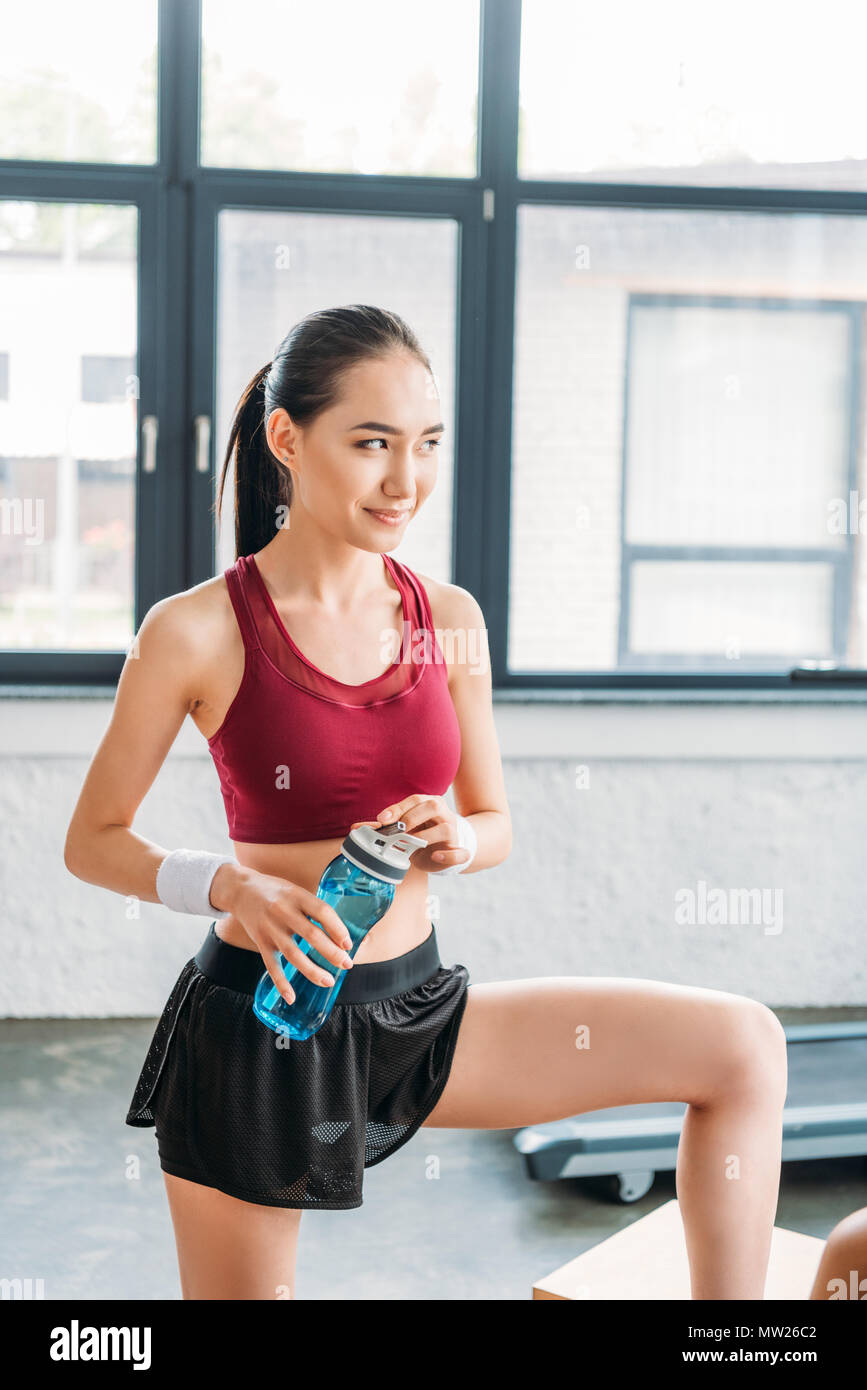 smiling asian sportswoman with bottle of water at gym Stock Photo - Alamy