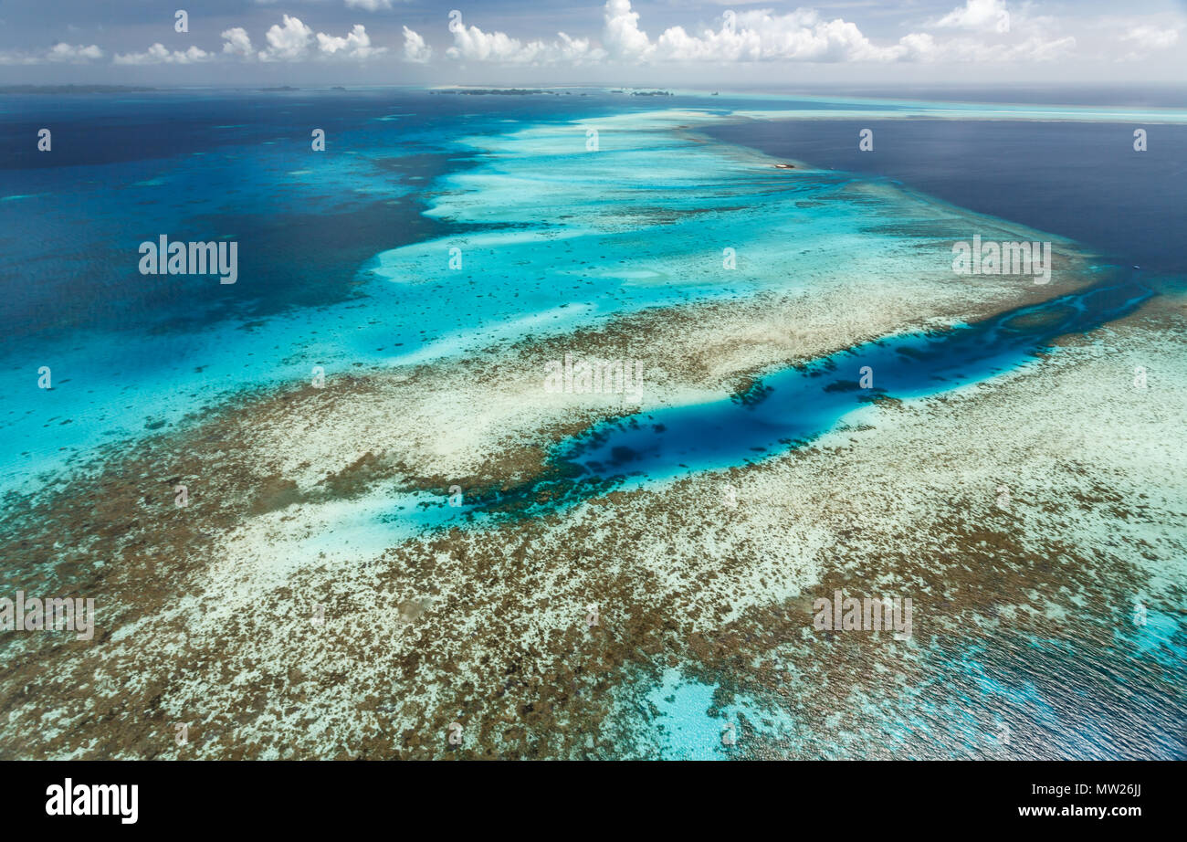 Colorful aerial view of large expanse of coral reefs and white sandbars stretching to the horizon in a zig zag pattern Stock Photo