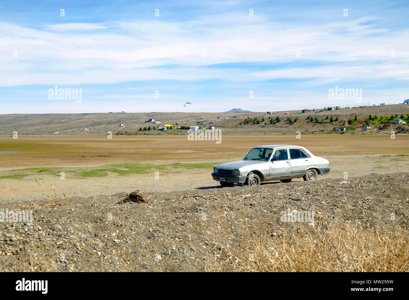 An isolated car is parked in El Calafate. The photo was taken during spring. In summer, Lake Argentino grows and floods this part of the city. Stock Photo