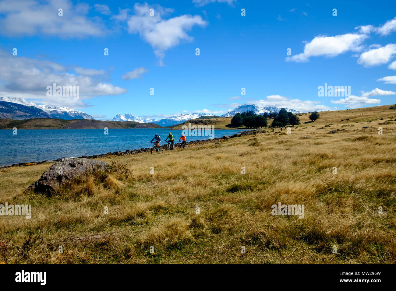 Puerto Natales, Magallanes / Chile - October 16 2016: Mountain bikers ride along a lake in the spectacular surroundings of Puerto Natales, Chile. Stock Photo