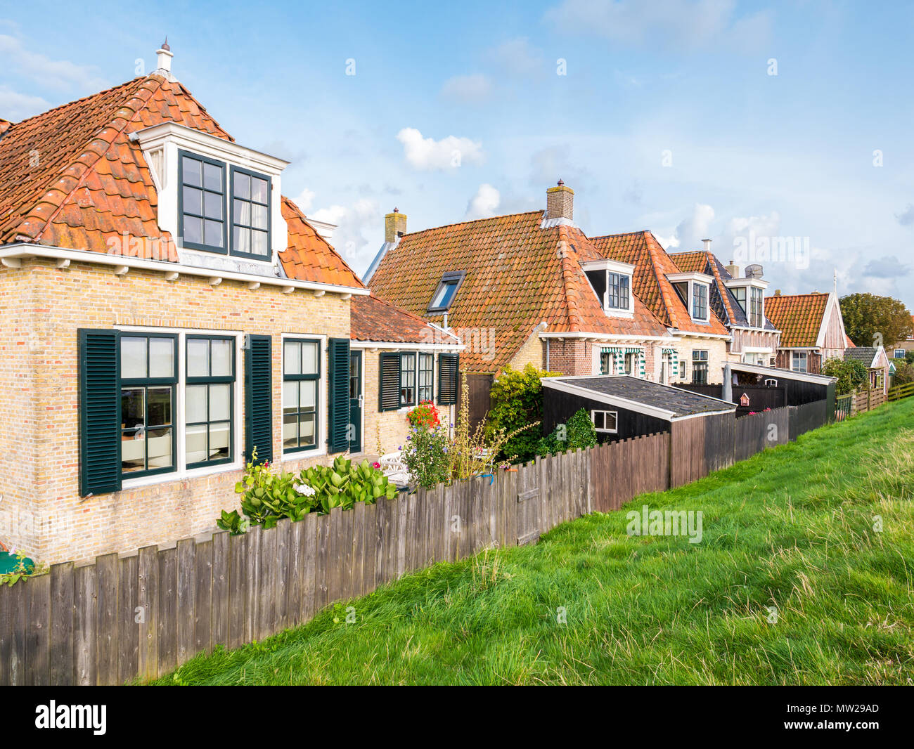 Small back yards of old cottages alongside dike in historic town of Makkum, Friesland, Netherlands Stock Photo