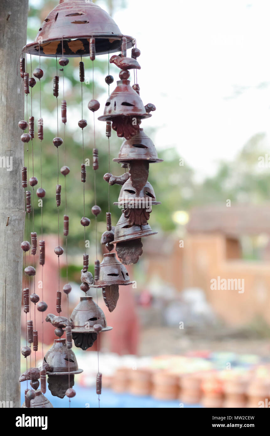 Beautiful garden ornaments—bells, beads, birds—made of clay, suspended from a pole, on sale at Shilparamam arts & crafts village in Hyderabad, India. Stock Photo