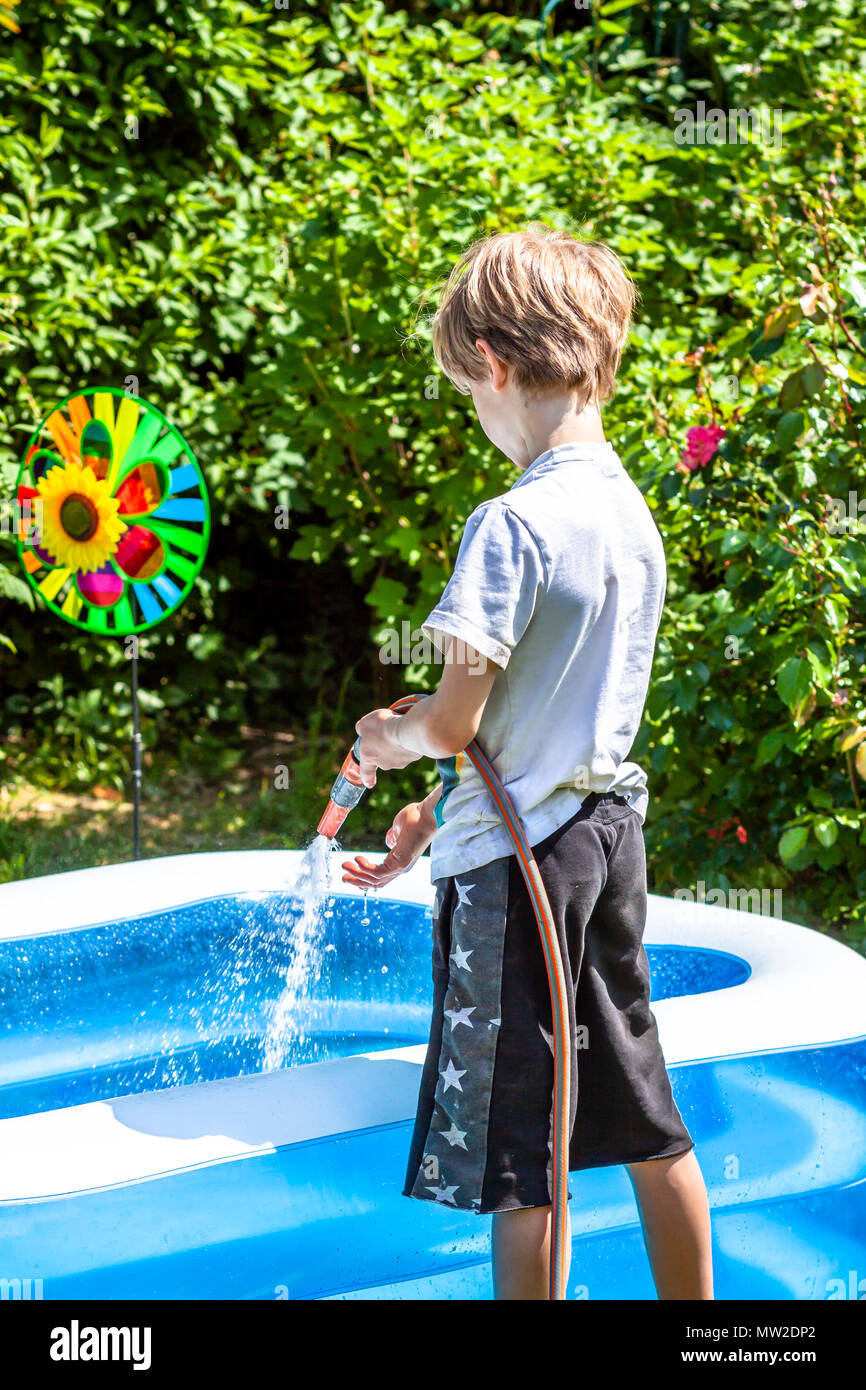 Little Boy Filling Filling Swimming Pool With Water Stock Photo - Alamy