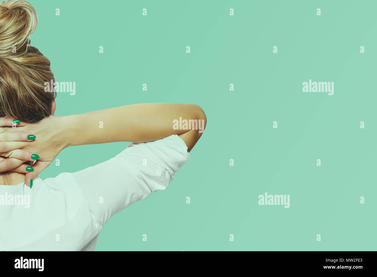 Woman relaxes, arms folded around her neck, resting. The woman has put