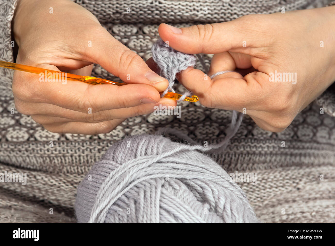 woman hands knitting with crochet hook and grey yarn Stock Photo Alamy