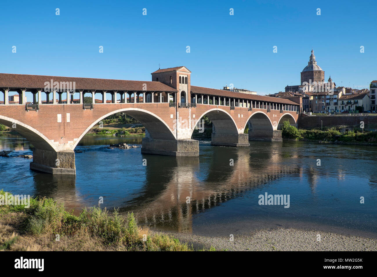Italy, Lombardy, Pavia: the 'Ponte Corto' covered bridge across the Ticino river. In the background, the cathedral Stock Photo