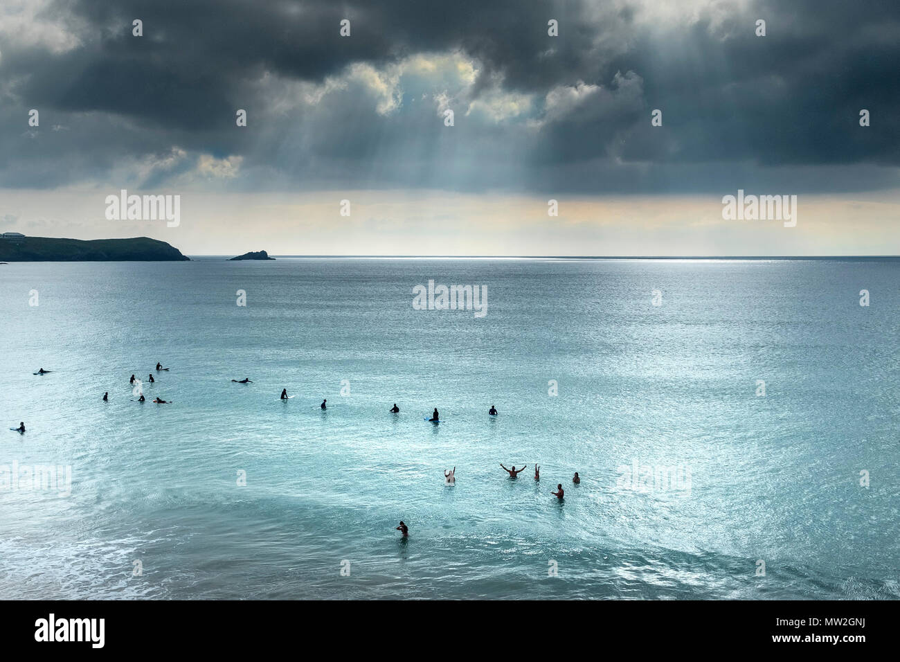 Surfers waiting for a wave on a calm sea at Fistral in Newquay in Cornwall. Stock Photo