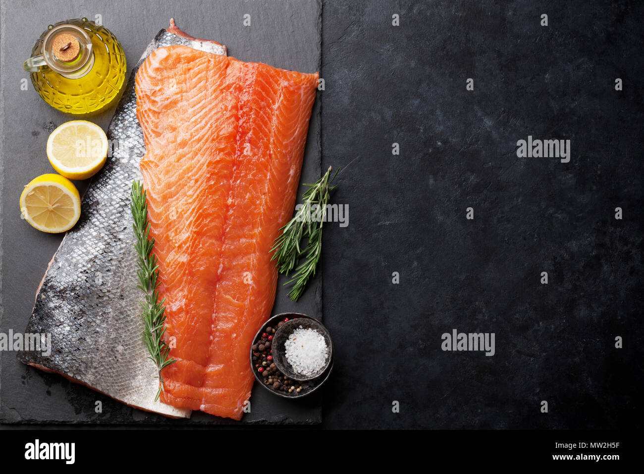 Raw salmon fish fillet with spices cooking on cutting board. Top view ...