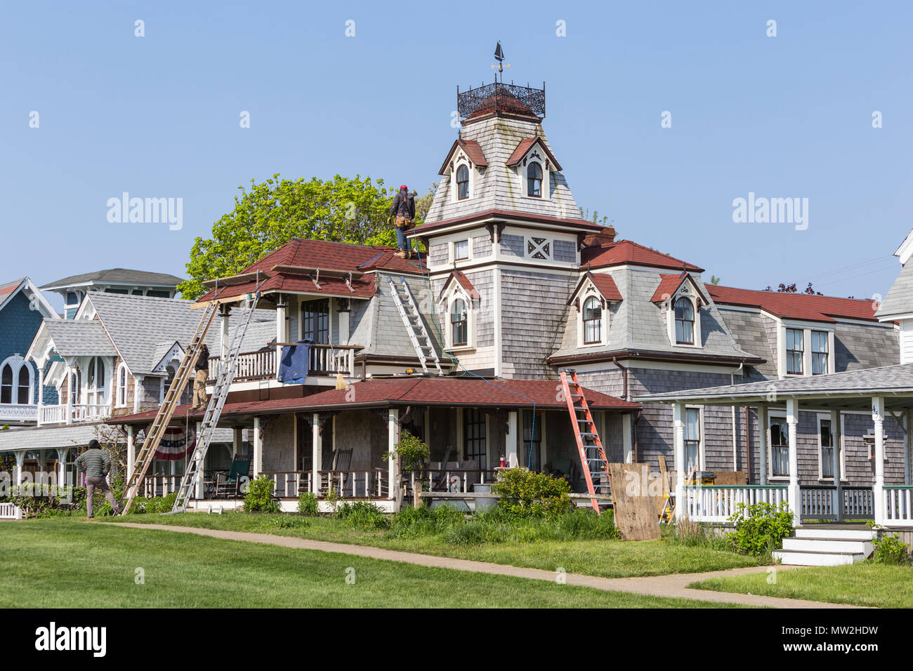 Workers make spring roof repairs to a Victorian era home on Ocean Avenue in Oak Bluffs, Massachusetts on Martha's Vineyard. Stock Photo