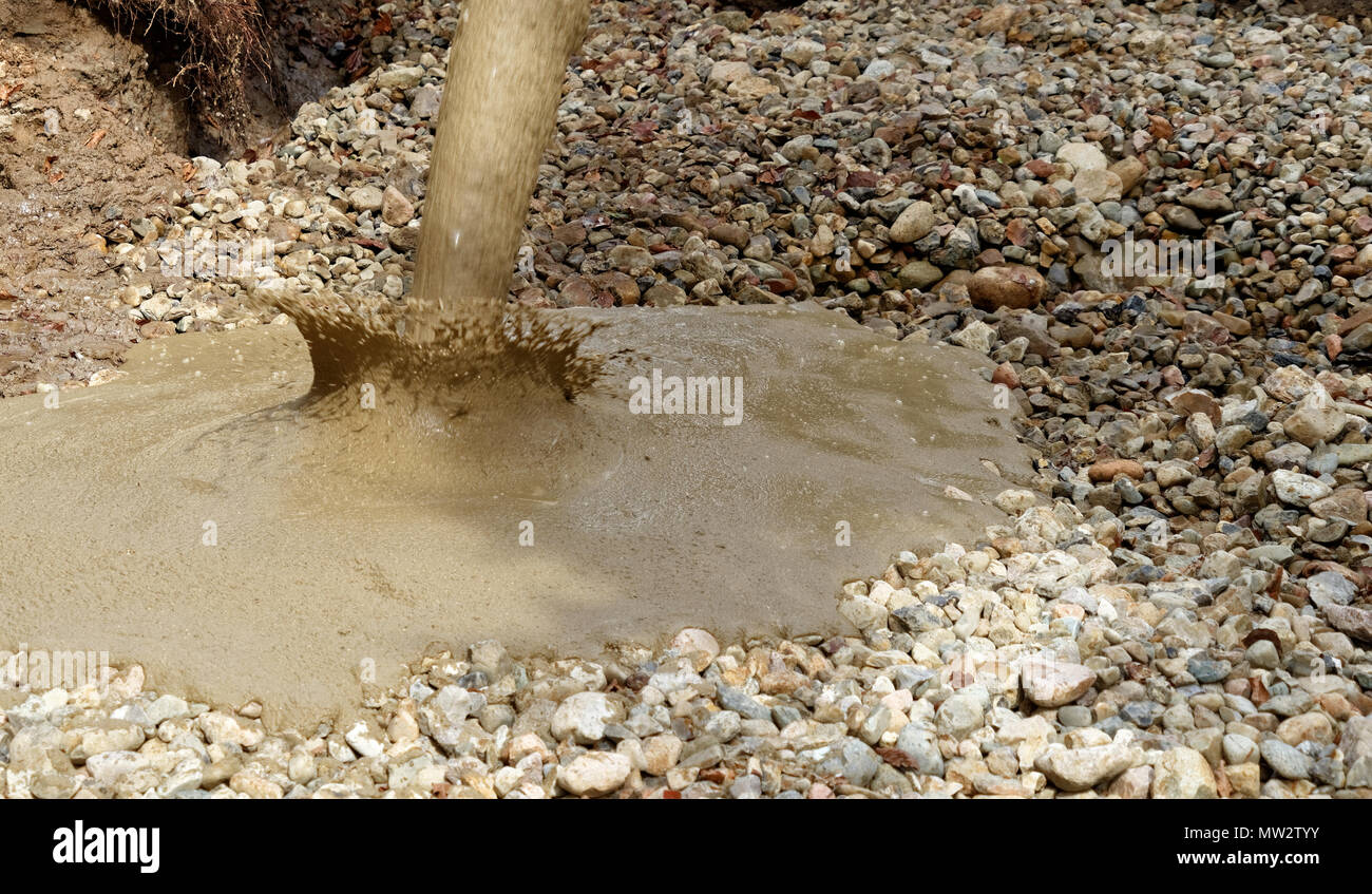 Liquid soil is poured from the concrete mixer onto the floor of the