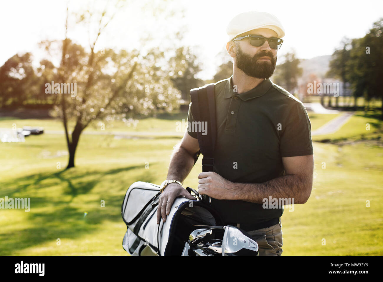 Golf player holding a golf club in golf course Stock Photo